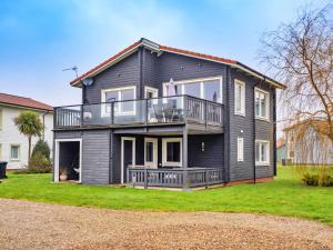 a black house with a balcony on a yard at Finest Retreats - Oasis 41 in Fritton