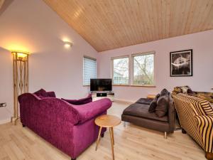 a living room with a purple couch and a chair at Finest Retreats - Oasis 41 in Fritton