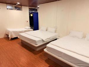 two beds in a room with white sheets at Aetheria Estate Retreat in Chikmagalūr