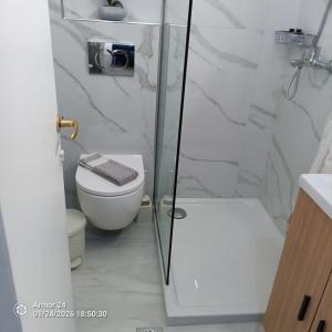 a bathroom with a toilet and a glass shower at Evdoxia - Piccola Casa Corfu Town in Ágios Rókkos