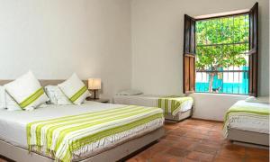 a bedroom with two beds and a window at Hotel San German in Girardot +39 photos