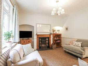 a living room with a couch and a fireplace at 2 Aqueduct Cottages in Wrexham