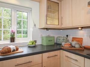 a kitchen with wooden cabinets and a counter top at 2 Aqueduct Cottages in Wrexham
