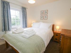 a bedroom with a bed with two towels on it at 2 Aqueduct Cottages in Wrexham