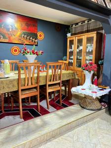 a dining room with a table and chairs and a vase of flowers at Esther Villas Home in Boma la Ngombe