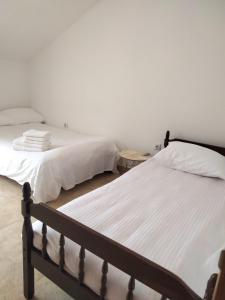 two beds sitting next to each other in a bedroom at Hillside Haven in Sutorina