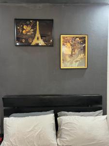 two framed pictures on a wall above a bed at Beni'o Suite in Adiapo-Doumé