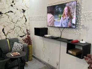 a living room with a tv on a wall at Beni'o Suite in Adiapo-Doumé +4 photos