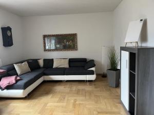 a living room with a black and white couch at Ferienwohnung "Am Malerweg" Lohmen in Lohmen