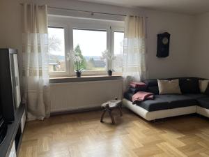 a living room with a couch and a window at Ferienwohnung "Am Malerweg" Lohmen in Lohmen