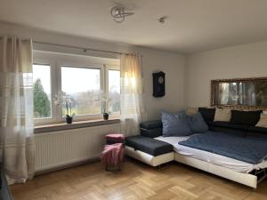 a bedroom with a bed and a couch and a window at Ferienwohnung "Am Malerweg" Lohmen in Lohmen