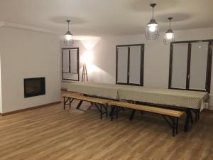 a row of benches in a room with wooden floors at Casa Campo in Abay