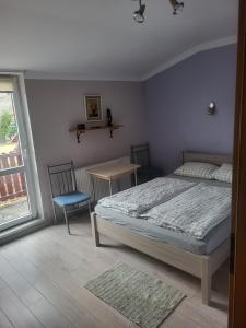 a bedroom with a bed and a table and chairs at Tyrolczyk in Szklarska Poręba