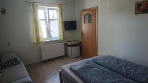 a bedroom with a bed and a window and a chair at Tyrolczyk in Szklarska Poręba