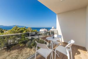 a balcony with a table and chairs and the ocean at Inamore in Gradac