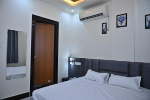 a bedroom with a bed and a brown door at Hotel Radhe in Bhind
