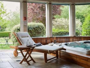 Zimmer mit einer Badewanne, einem Stuhl und einem Tisch in der Unterkunft Les Prés D'ondine in Sélestat