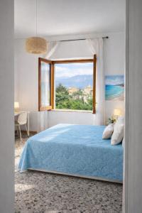 a bedroom with a blue bed and a window at Sorrento life 3 in Sant'Agnello