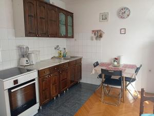 a kitchen with wooden cabinets and a table in it at Kleopa in Pale +17 photos
