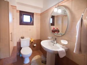 a bathroom with a toilet and a sink and a mirror at Rodi House in Lygia +32 photos