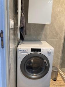 a washer and dryer with a white cabinet above it at Studio Vintage avec cheminée décorative in Villefranche-sur-Saône +2 photos