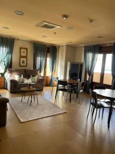 a living room with a couch and tables and chairs at Hostal Jijones in Villarrubia de los Ojos