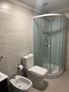 a bathroom with a shower and a toilet and a sink at Las Maras Apart. in Rada Tilly +8 photos