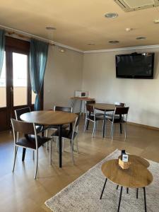 a room with tables and chairs and a flat screen tv at Hostal Jijones in Villarrubia de los Ojos +14 photos