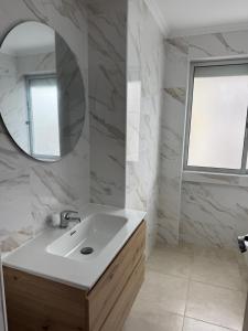 a white bathroom with a sink and a mirror at Cascais Garden House 101 in Cascais