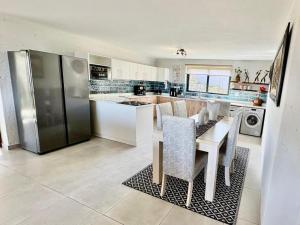 a kitchen with a table with chairs and a refrigerator at Sea La Mer Villa in Wilderness