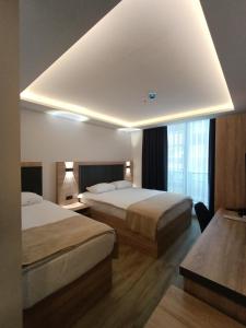 a hotel room with two beds and a window at Döşemealtı Konfor Hotel in Dosemealti