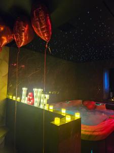 a room with balloons and a bed with lights at Suite romantique avec jaccuzzi - proche des lacs - La secrète room in La Mure