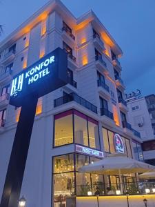a hotel with a sign in front of it at Döşemealtı Konfor Hotel in Dosemealti