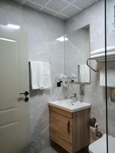 a bathroom with a sink and a mirror at Döşemealtı Konfor Hotel in Dosemealti +14 photos