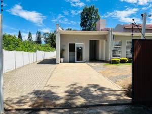 a white house with a driveway in front of it at Umsobomvu Guest House in Mthatha