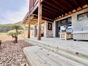 a porch of a house with a wooden deck at Sea La Mer Villa in Wilderness