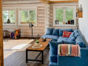 a living room with a blue couch and a table at Modern Log Cabin On Adelsö in Adelsö