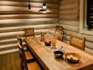 a dining room with a wooden table and chairs at Modern Log Cabin On Adelsö in Adelsö