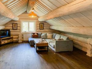 a living room with a couch and a tv at Modern Log Cabin On Adelsö in Adelsö