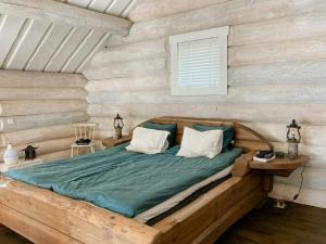 a bed in a room with a wooden wall at Modern Log Cabin On Adelsö in Adelsö