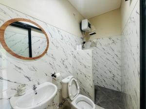 a bathroom with a sink and a toilet and a mirror at Umah Kak Pasek in Jimbaran