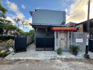 a building with a gate and a sign on it at Umah Kak Pasek in Jimbaran