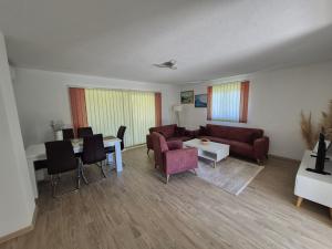 ein Wohnzimmer mit Sofa, Tisch und Stühlen in der Unterkunft Orhidea in Bihać
