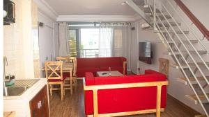 a living room with a red couch and a table at Résidence Houé in Cotonou