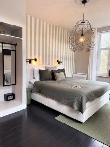 a bedroom with a large bed and a chandelier at Villa V - Petit Hôtel in Valkenburg