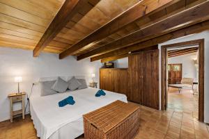 a bedroom with a large white bed and wooden ceilings at Casa Piscina Casa Principal in Artá +57 photos