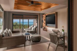 a living room with a couch and a television at The Ritz-Carlton, Koh Samui in Choeng Mon Beach
