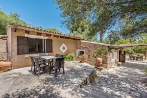 a patio with a table and chairs in front of a house at Casa Piscina Casa Principal in Artá
