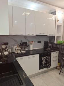 a kitchen with white cabinets and a black counter top at ANY MARY Apart ZONA 0 in Tulcea