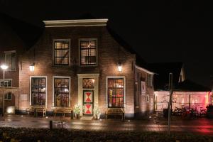 a brick building at night with lights in the windows at Herberg De Hollandsche Leeuw in Nieuwkoop